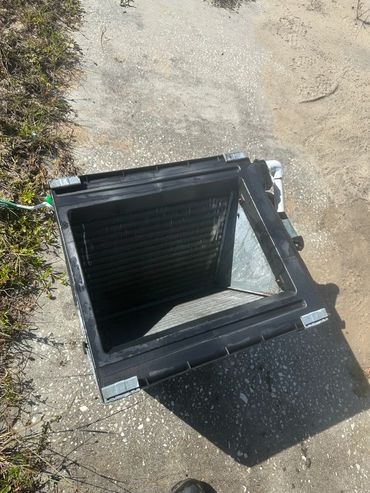 A black plastic container on a pebble ground.