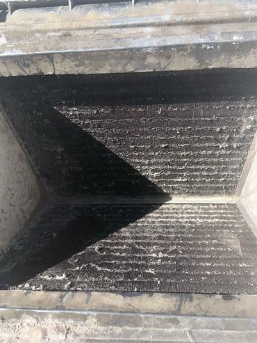 A dirty and dusty filter inside a metallic frame.
