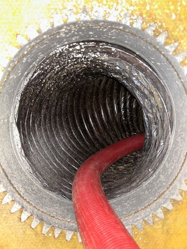 View inside a metallic flexible duct with a red hose.