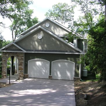 Two story home with concrete siding with  stone accents and stone to grade.