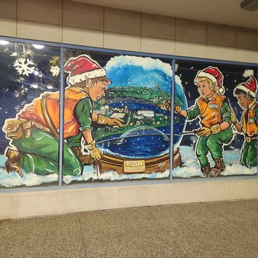 Holiday window art at 1701 5th Avenue - elves and snowglobe with Quad Cities scene