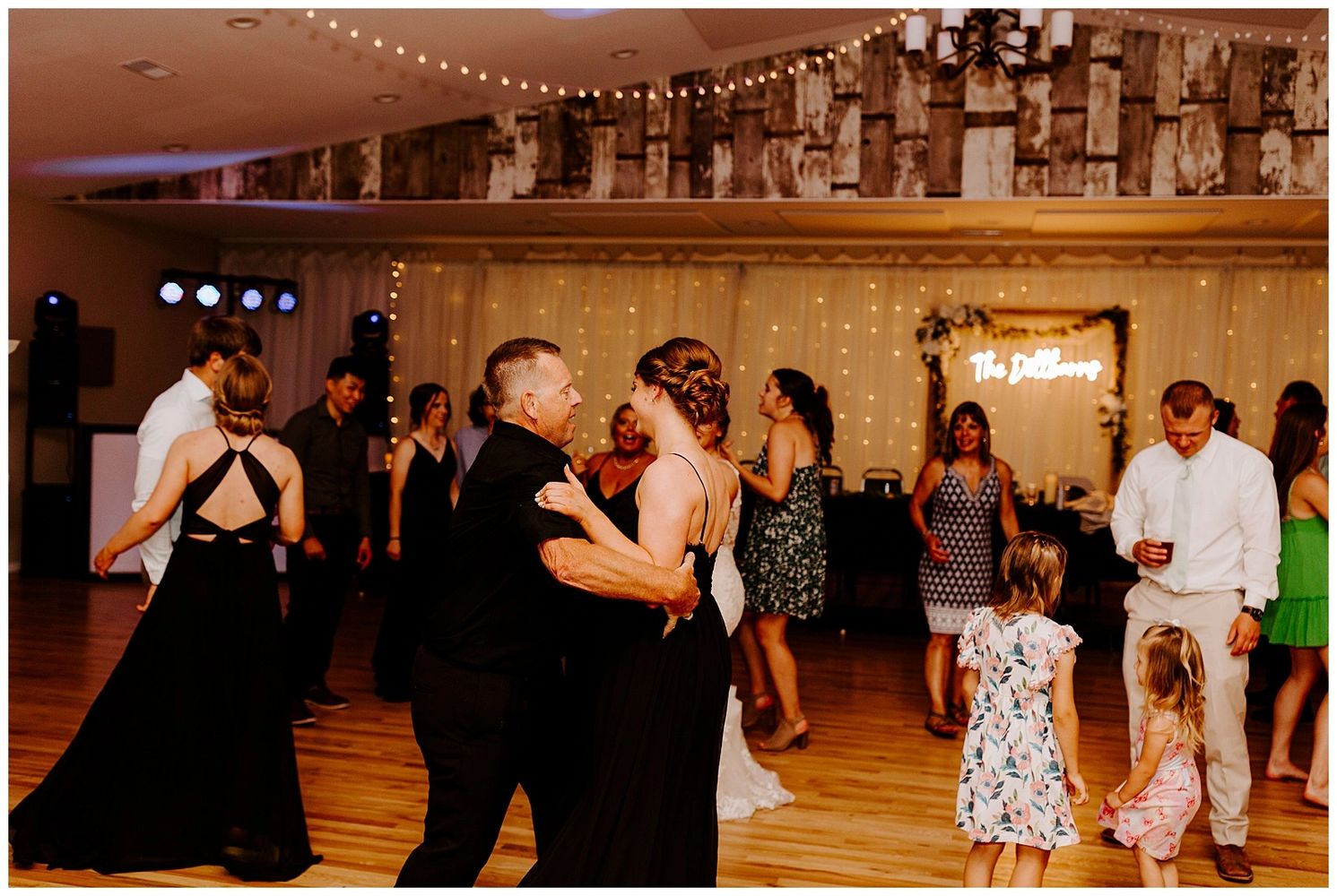 Guests dancing and enjoying a wedding reception indoors with warm lighting.