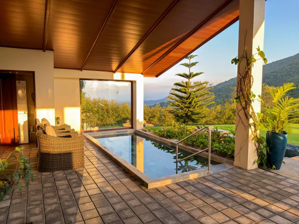 Cozy outdoor seating area beside a small pool with mountain views.