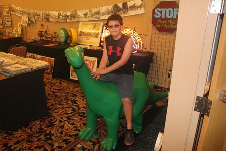 Little boy on a green Sinclair dinosaur
