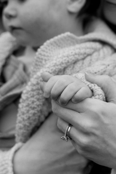 Black and white family photography: baby holding mums hand