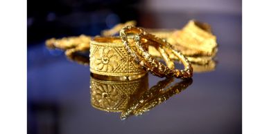 Gold jewelry reflecting on a surface.