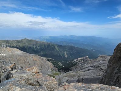 Scenic mountain range under a blue sky with scattered clouds.