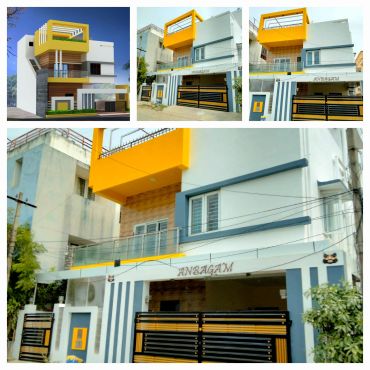 Modern house with yellow accents and black gates.
