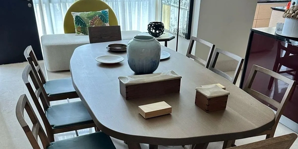 Modern dining table with six chairs and decorative items.