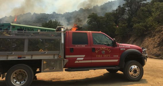 Hellsgate Fire brush truck in front of Payson Hot Shot truck during a wildland fire