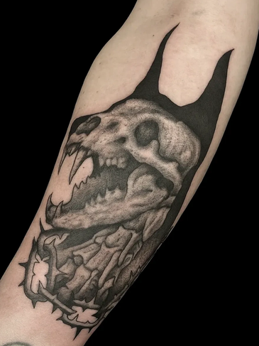 Black and grey dog skull tattoo with bat ears.