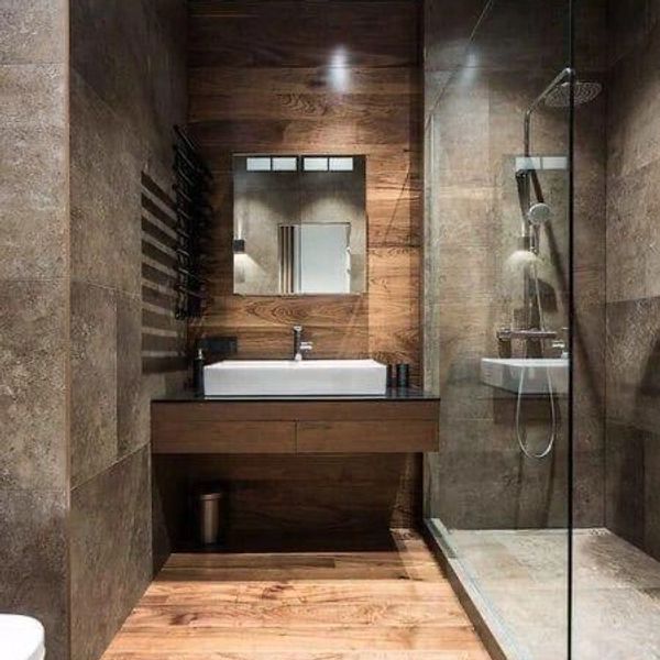 Bathroom setting; picturing a sink and show with wood effect tiles