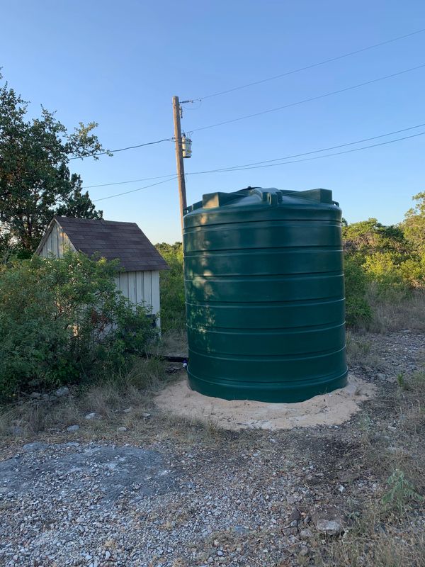 Sand bed under water storage tank to accommodate for slope