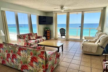 Bright living room with tropical sofas and ocean view balcony.