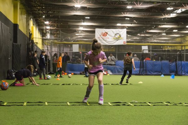Youth soccer player using floor ladder to complete an agility drill