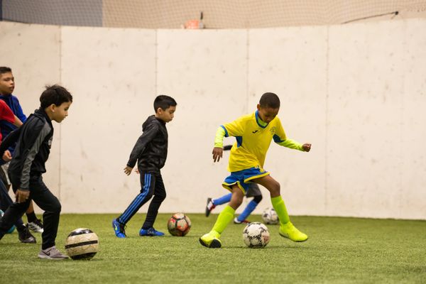 Youth soccer players dribbling the ball