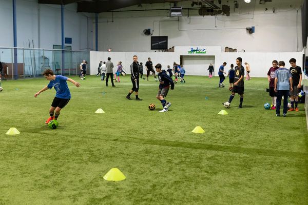 Youth soccer players engaged in a dribbling drill