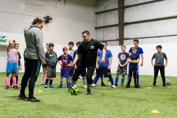 Soccer coaching showing youth players how to dribble