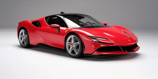 Sleek red Ferrari sports car with black roof on a gray background.