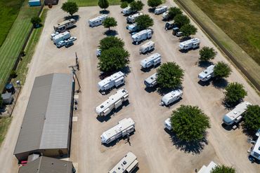 Aerial view of a parking lot with RVs and trees.