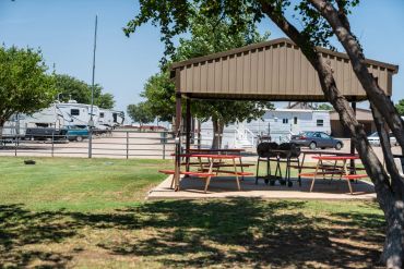 Picnic area with grills near RVs.