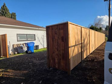 Newly installed wooden fence with a clear blue sky.