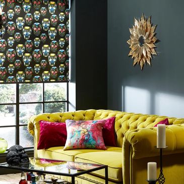 skull print roller blind, black walls yellow sofa pink cushions