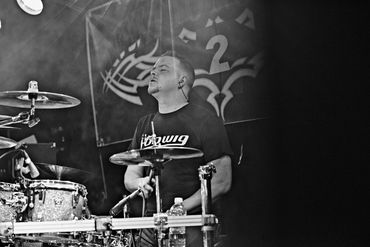 Black and white image of a drummer deeply immersed in playing.