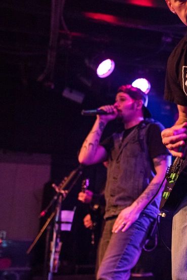 Band performing live with vibrant stage lighting and energetic musicians.