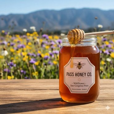 Jar of wildflower honey with a honey dipper, set against a colorful wildflower field and mountains.
