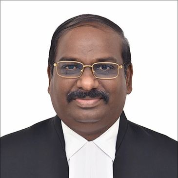 Portrait of a man in formal legal attire with glasses.