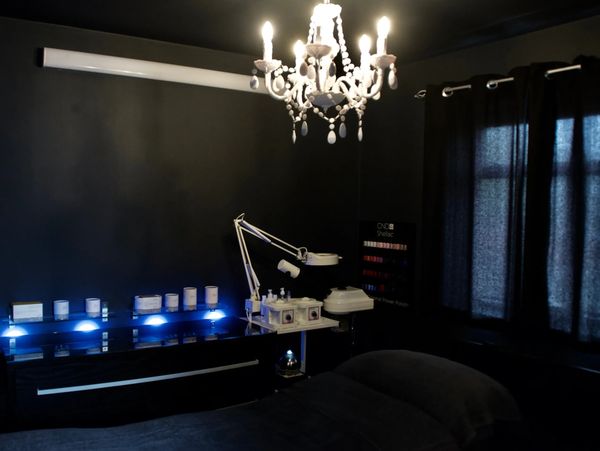 Dark room with a chandelier and beauty treatment setup.