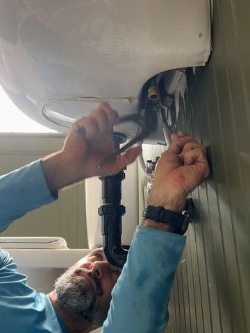 Me removing old plumbing hardware and hoses to add a new one on a bathroom remodel.
