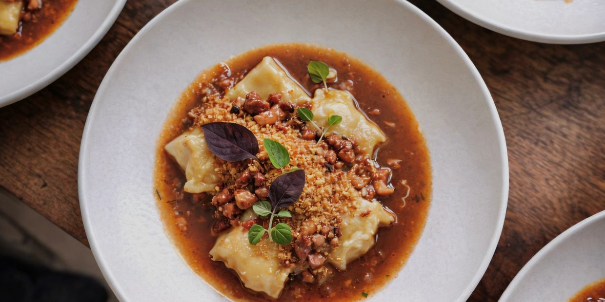Gourmet ravioli in rich sauce with herbs and crushed nuts.