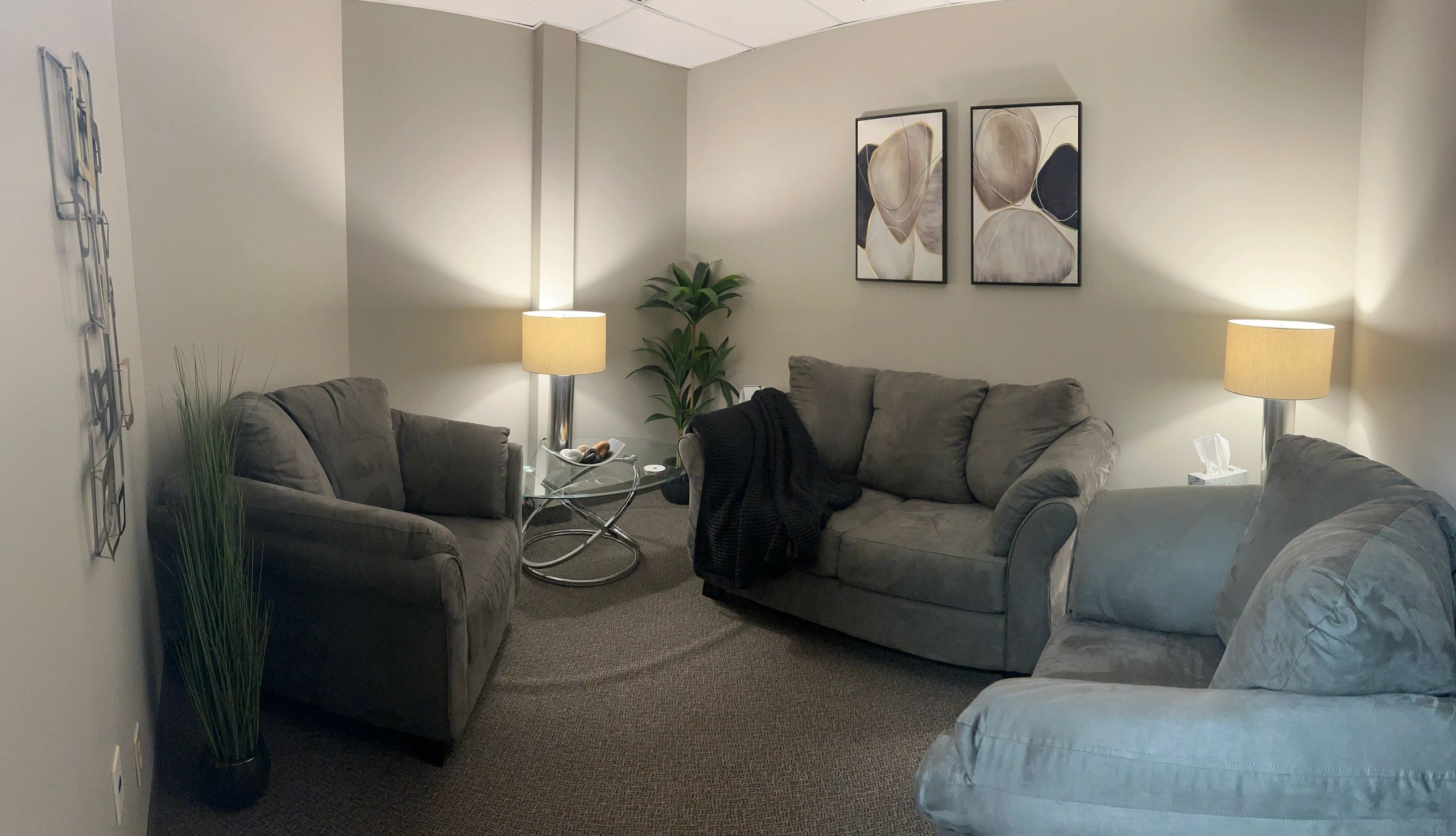 A couch, two chairs, warm lamps, and abstract art furnish the Talk Therapy Room at NCS.
