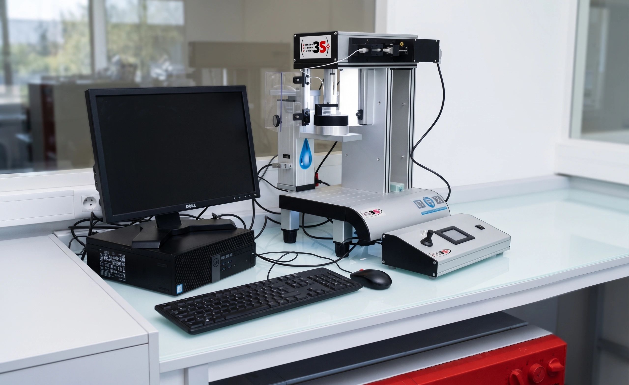Scientific instrument setup with computer and specialized device on a lab desk.
