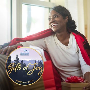 Gifts of Joy Winter Gift Drive Instagram post showing a woman with a gift
