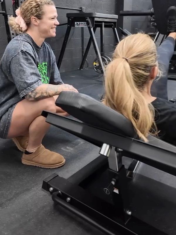 Two women engaging in a workout session at the gym.