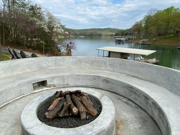concrete seating for 20 people with concrete fire pit and electrical features with logs