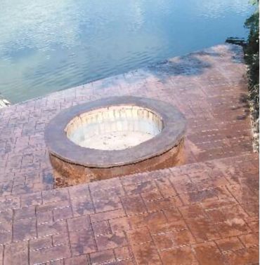decorative outdoor fire pit and concrete steps onto boat ramp