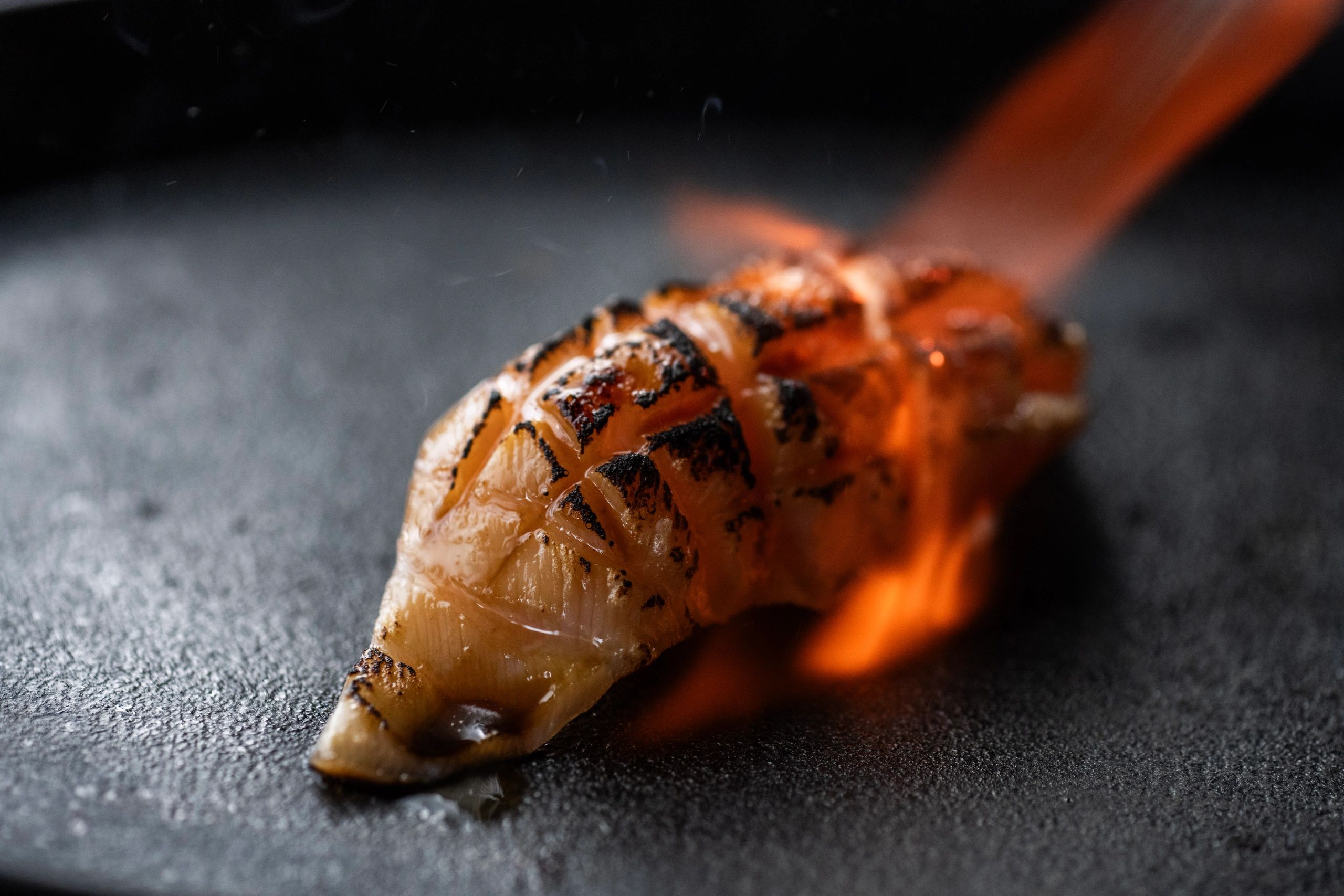 Torched and scored salmon nigiri with nori butter