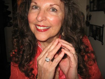 Elderly woman holding her hands together and smiling at the camera