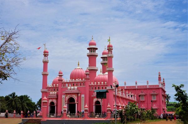 A large pink mosque with domes and minarets.