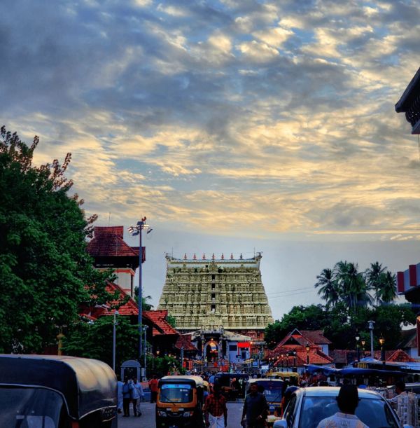 Crowded street leading to a temple under a cloudy sky.