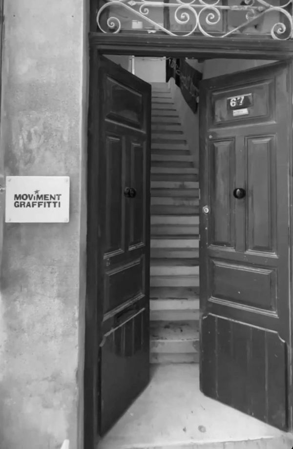 Open red double doors revealing a staircase inside a building.