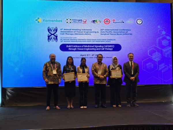 People holding certificates at a scientific conference.