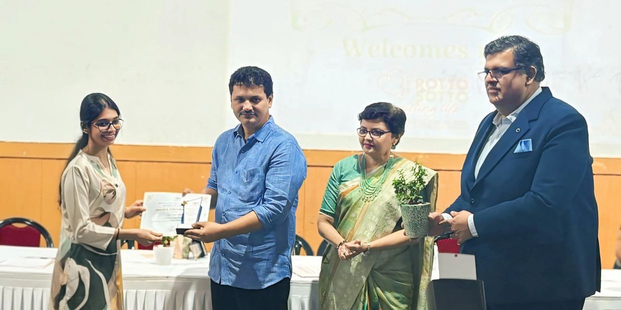 Award ceremony with certificate and plant exchange.