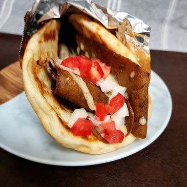 Donair with beef, tomato, onion and sauce wrapped in a pita