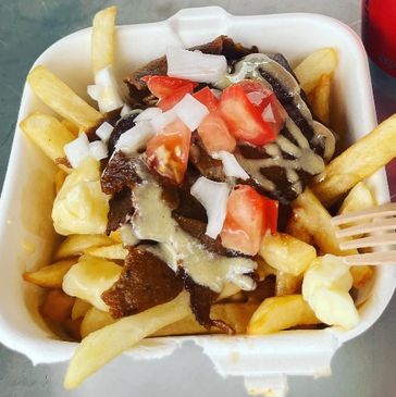 Poutine topped with donair meat, tomato, onion and donair sauce