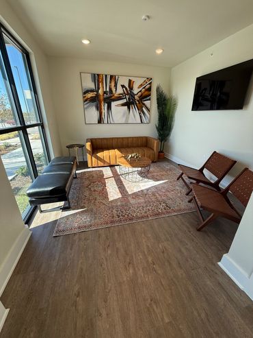 Cozy modern living room with leather furniture and large window.